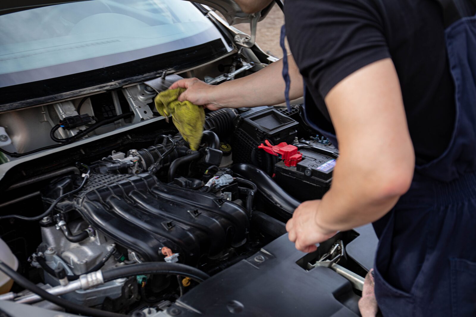 A technician working under the hood at R/T Automotive